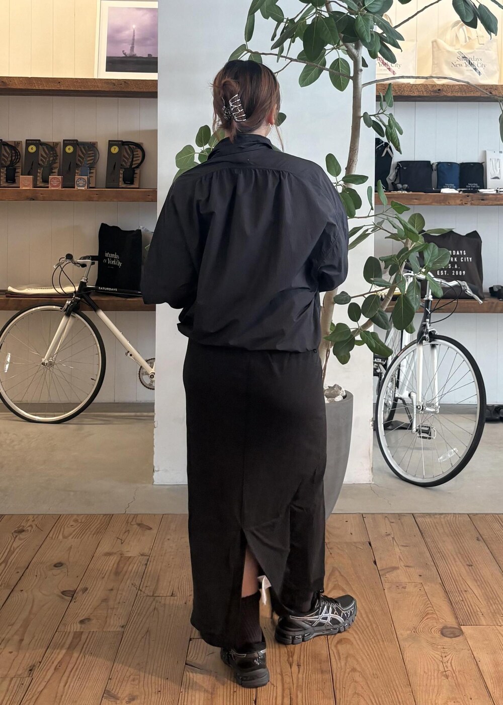 ブラック系のスカート、ブラック系のブルゾン、ホワイト系のTシャツ/カットソーを着用したレディースの春コーディネートの3枚目の写真