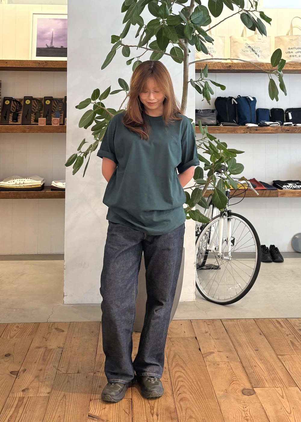 ブルー系のデニムパンツ、ブラック系のTシャツ/カットソー、ブラウン系のベルトを着用したレディースの夏コーディネートの3枚目の写真