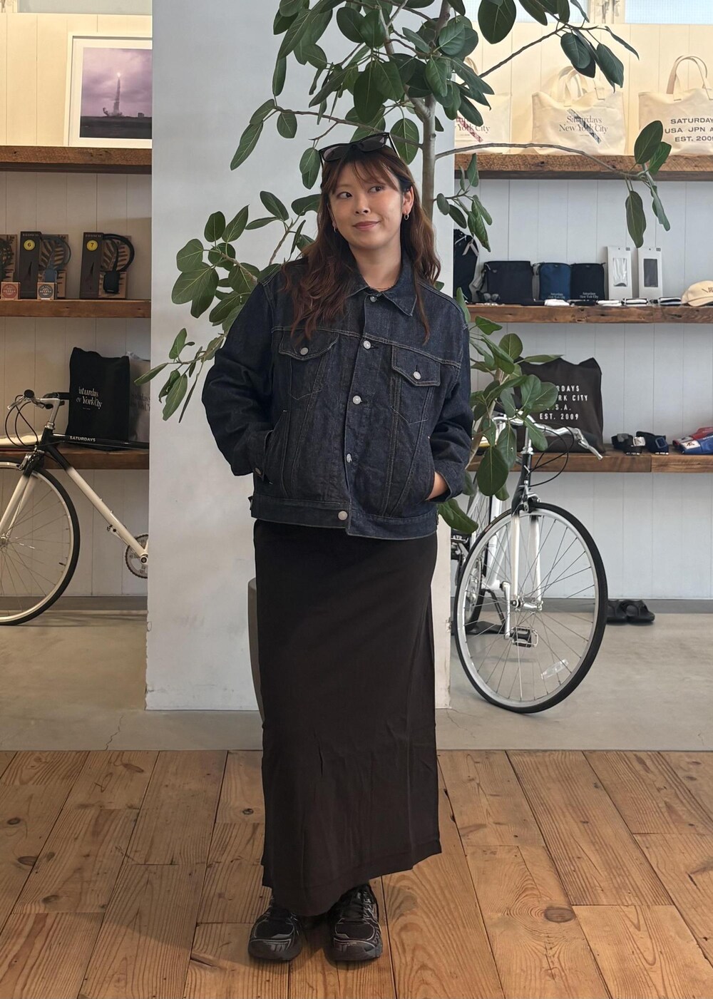 ブルー系のデニムジャケット、ブラック系のスカート、ブラック系のサングラスを着用したレディースの春コーディネートの2枚目の写真
