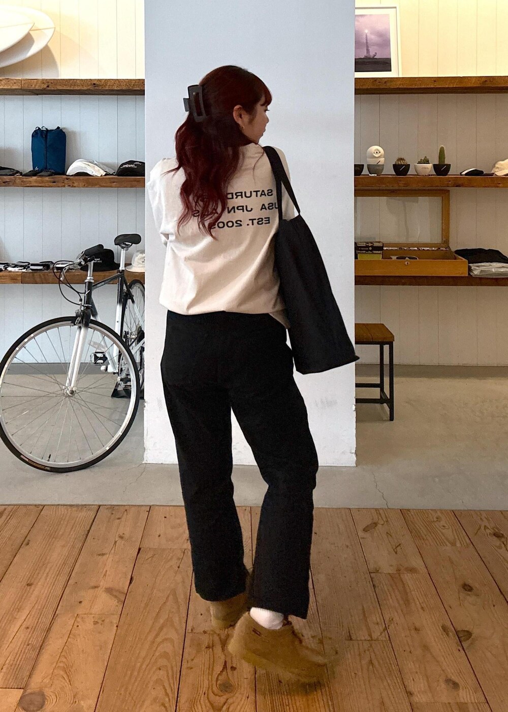 ブラック系のデニムパンツ、ブラック系のトートバッグ、ホワイト系のTシャツ/カットソーを着用したレディースの春コーディネートの4枚目の写真