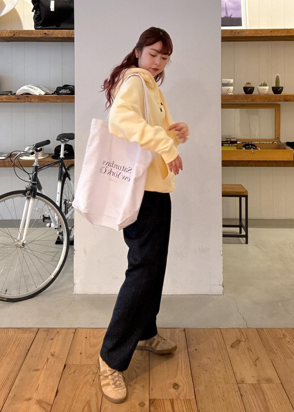 ベージュ系のパーカー、ホワイト系のトートバッグ、ブルー系のその他パンツを着用したレディースの春コーディネートの2枚目の写真