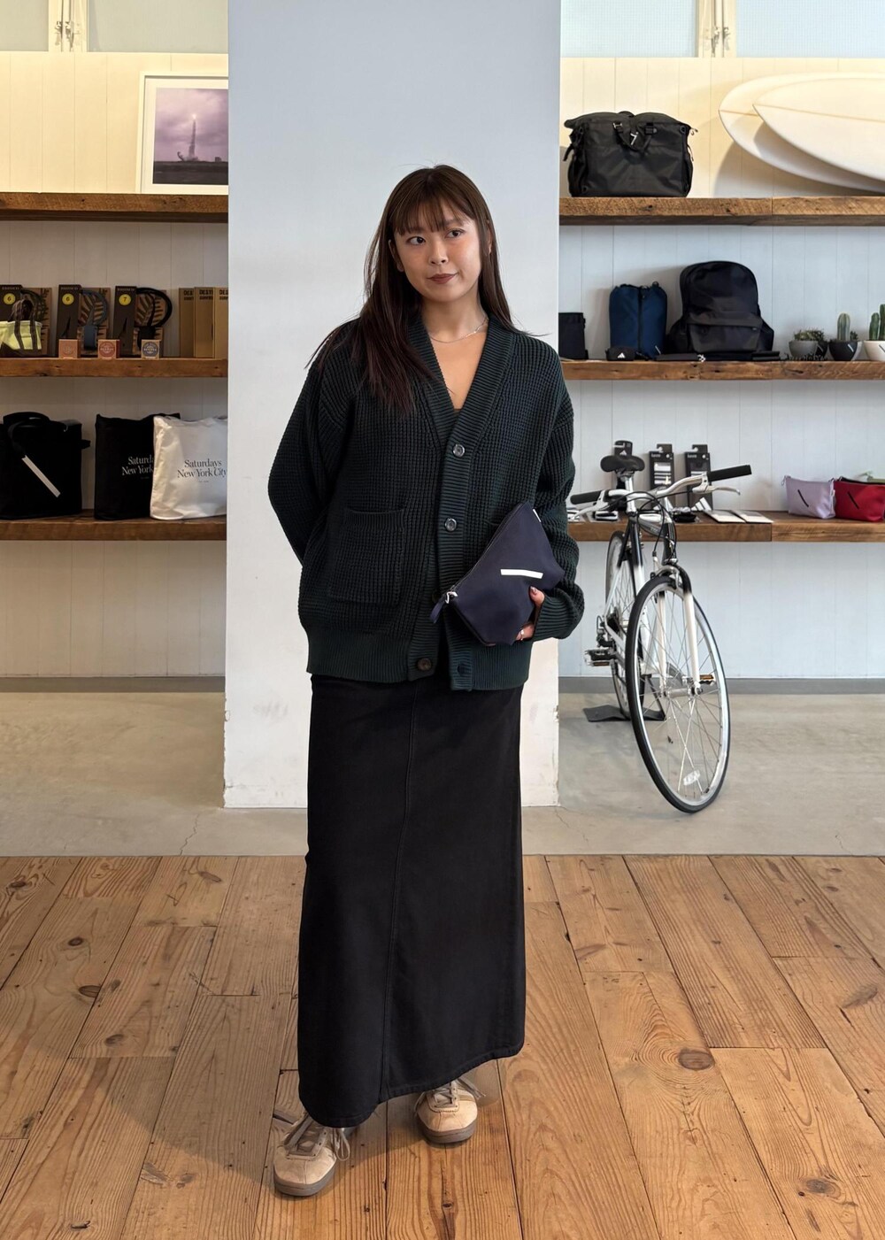 グリーン系のカーディガン/ボレロ、ブラック系のデニムスカートを着用したレディースの秋コーディネートの2枚目の写真