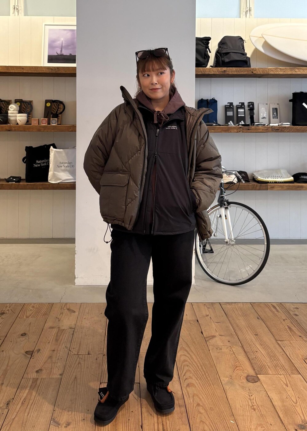 ブラック系のデニムパンツ、グリーン系のダウンジャケット/コート、ブラウン系のパーカーを着用したレディースの冬コーディネートの7枚目の写真