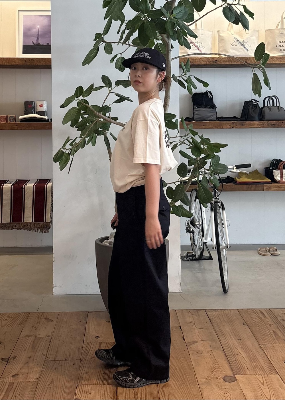 ホワイト系のTシャツ/カットソー、ブルー系のチノパンツ、ブルー系のキャップを着用したレディースの夏コーディネートの3枚目の写真