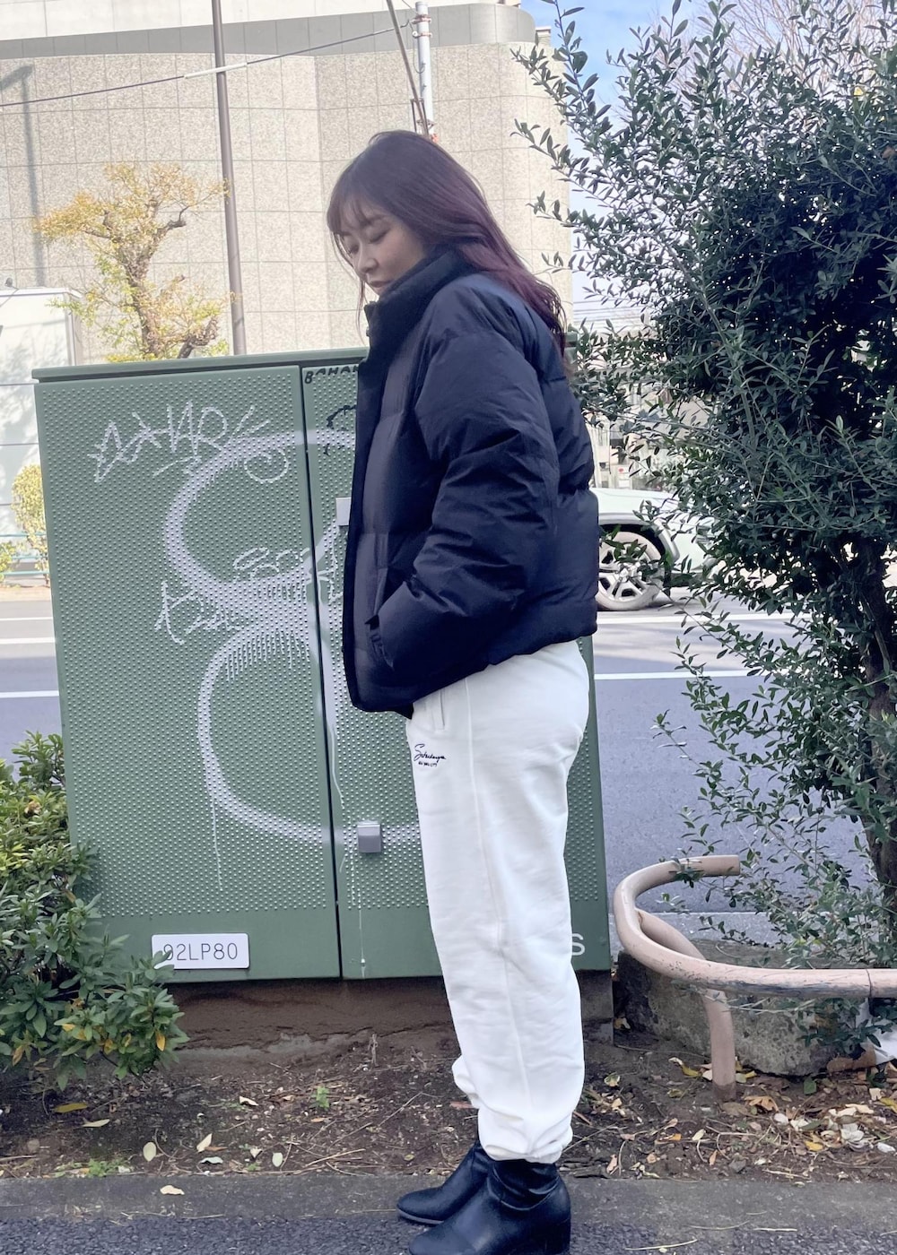 ホワイト系のスウェットパンツ、グレー系のニット/セーター、ブラック系のダウンジャケット/コートを着用したレディースの冬コーディネートの2枚目の写真
