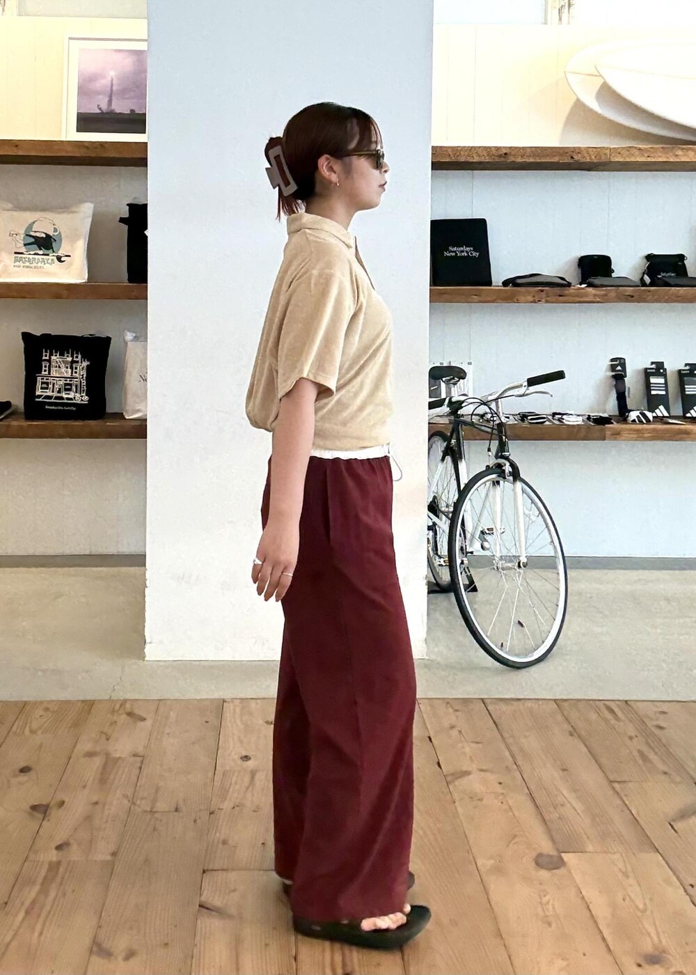 ベージュ系のポロシャツ、ブラック系のサンダル、レッド系のその他パンツを着用したレディースの夏コーディネートの5枚目の写真