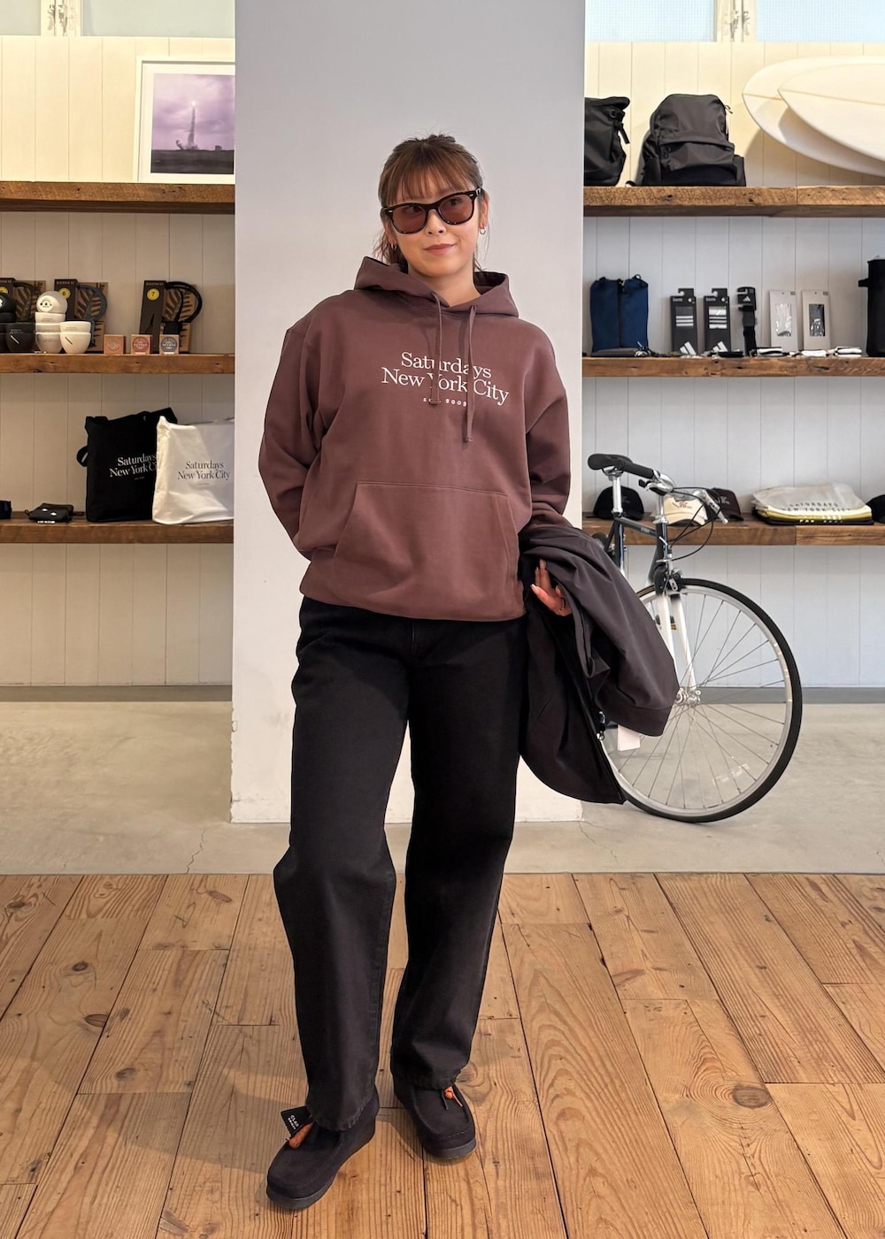 ブラック系のデニムパンツ、グリーン系のダウンジャケット/コート、ブラウン系のパーカーを着用したレディースの冬コーディネートの8枚目の写真