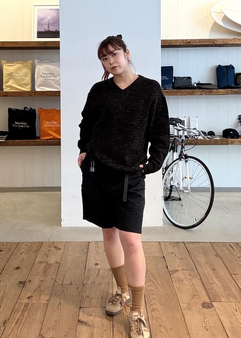 ブラック系のニット/セーター、ブラック系のその他パンツ、イエロー系のソックス/靴下を着用したレディースの春コーディネートの2枚目の写真