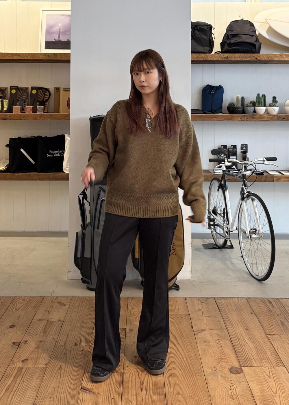 グリーン系のニット/セーター、ブラック系のキャップを着用したレディースの秋コーディネートの2枚目の写真