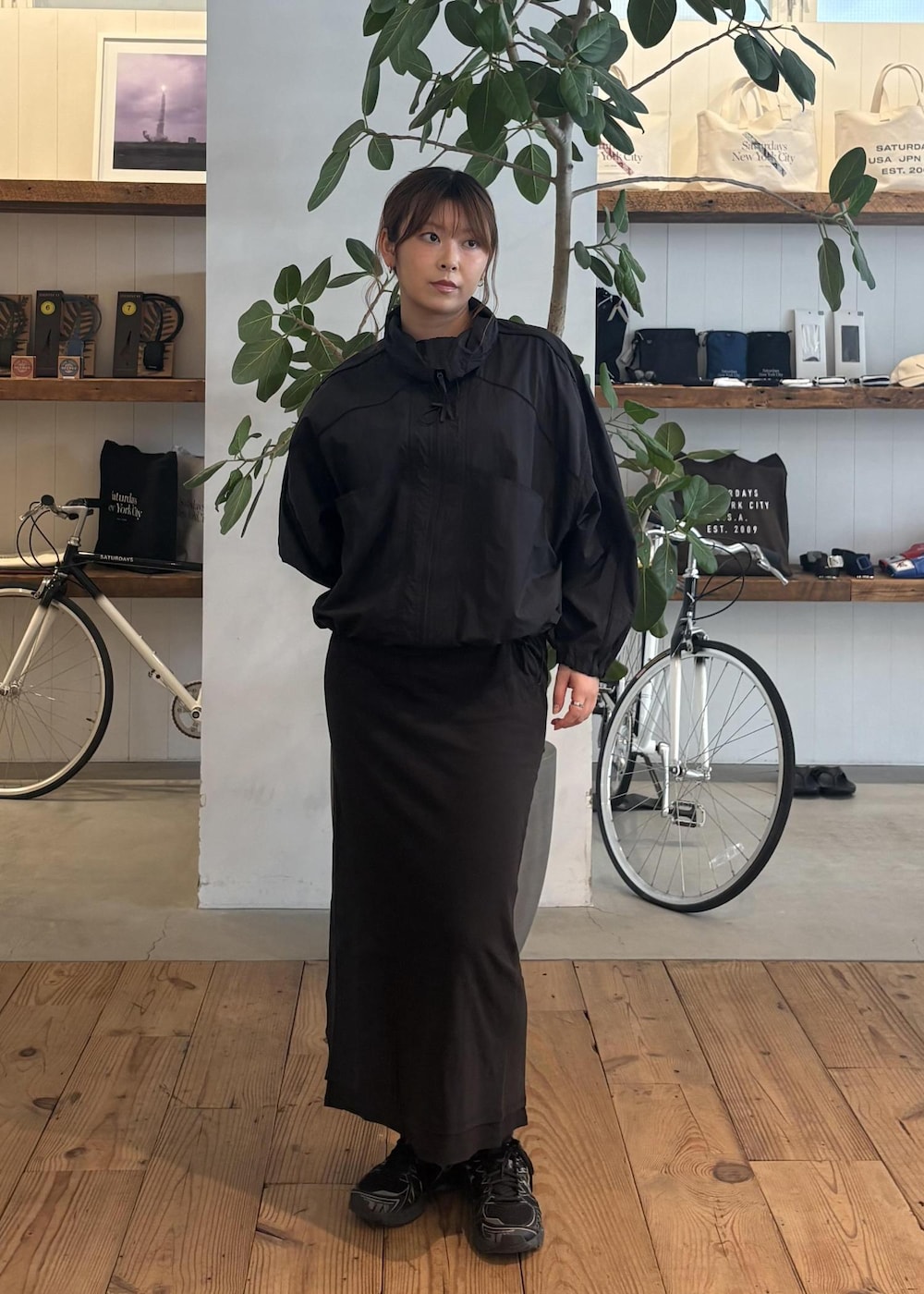 ブラック系のスカート、ブラック系のブルゾン、ホワイト系のTシャツ/カットソーを着用したレディースの春コーディネートの4枚目の写真