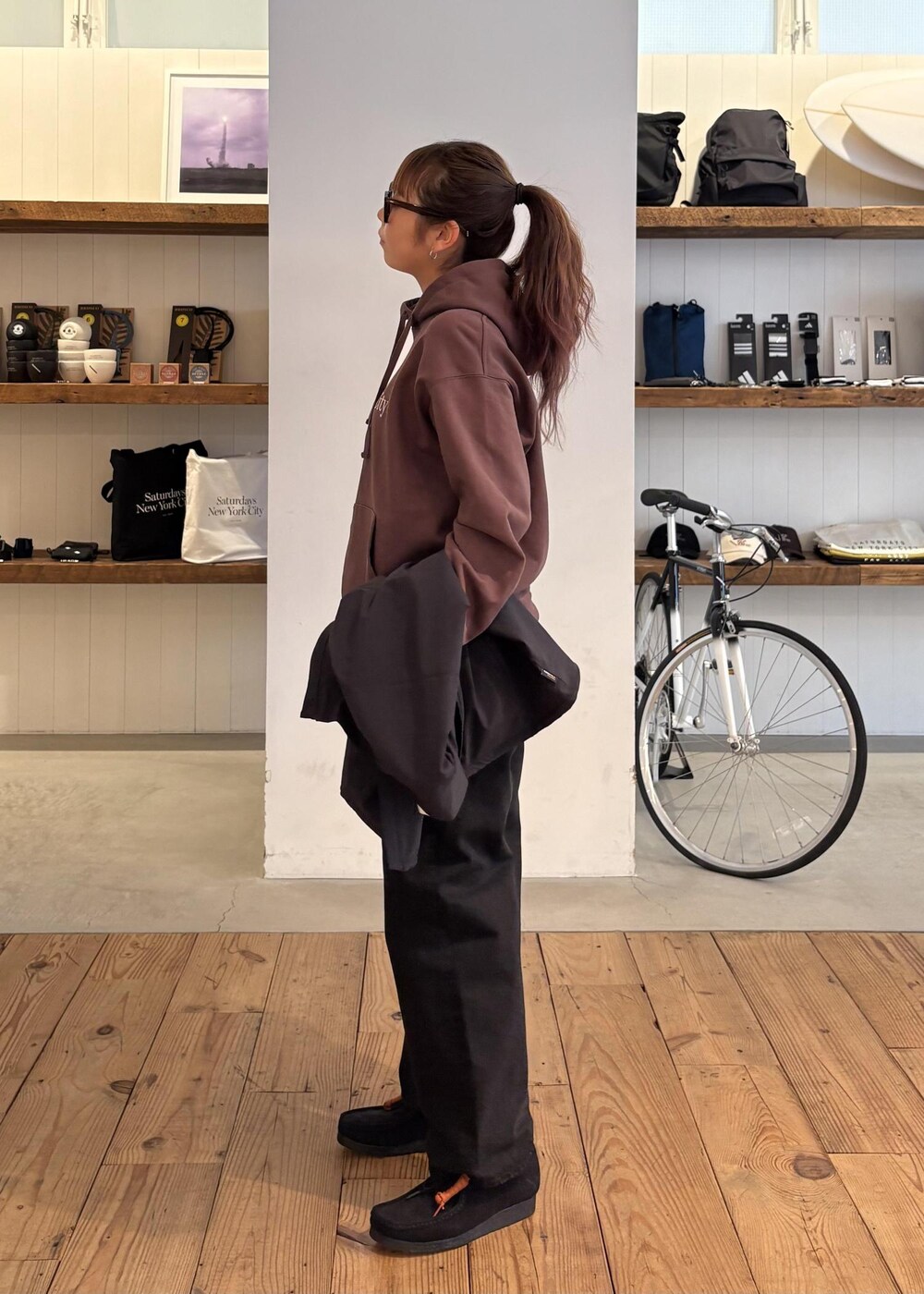 ブラック系のデニムパンツ、グリーン系のダウンジャケット/コート、ブラウン系のパーカーを着用したレディースの冬コーディネートの9枚目の写真