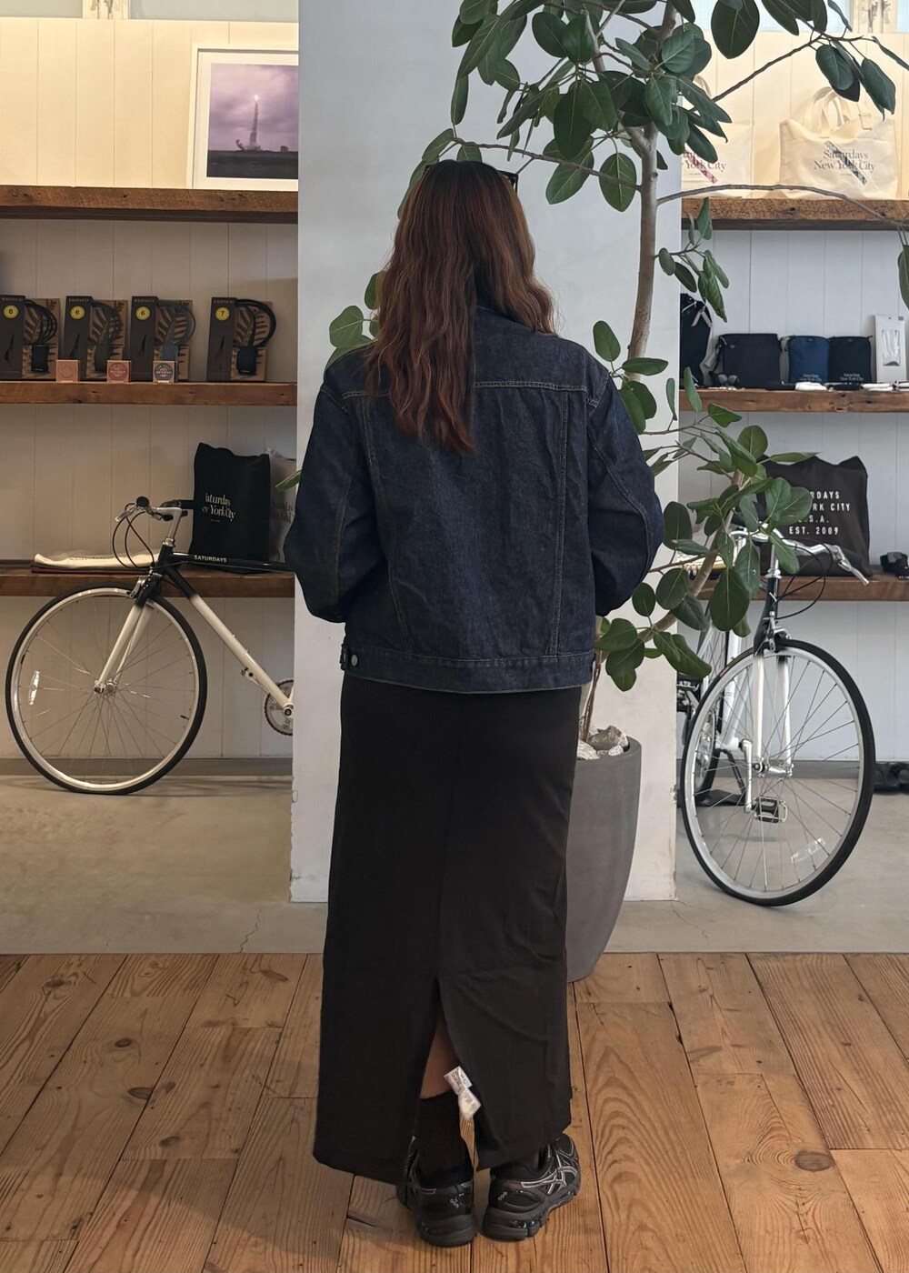 ブルー系のデニムジャケット、ブラック系のスカート、ブラック系のサングラスを着用したレディースの春コーディネートの5枚目の写真