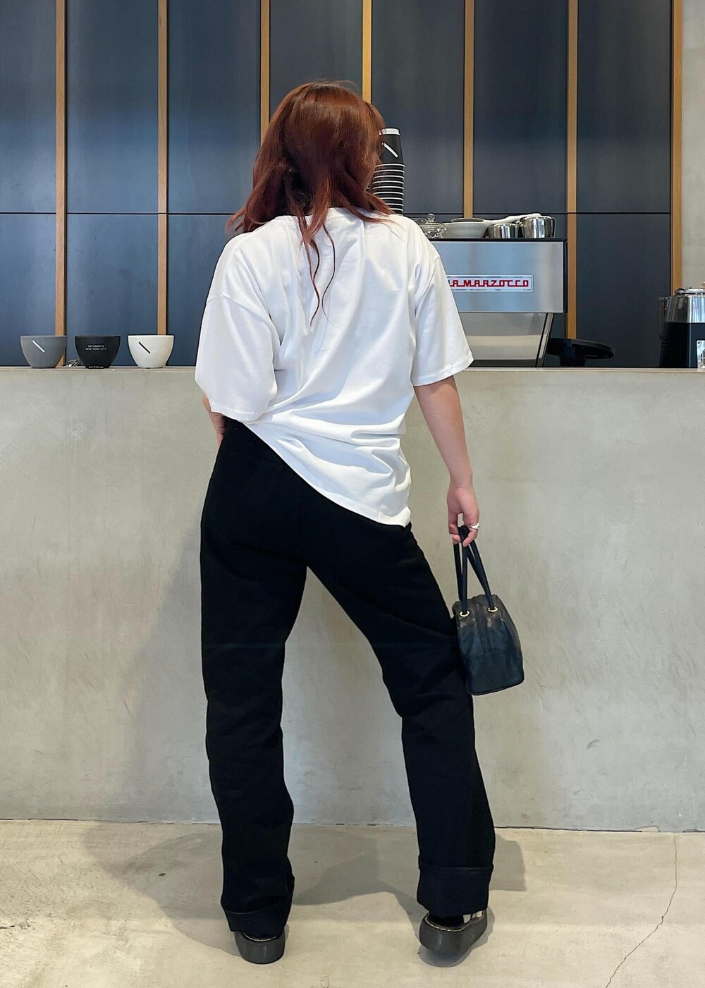 ブラック系のデニムパンツ、ホワイト系のTシャツ/カットソーを着用したレディースの夏コーディネートの4枚目の写真