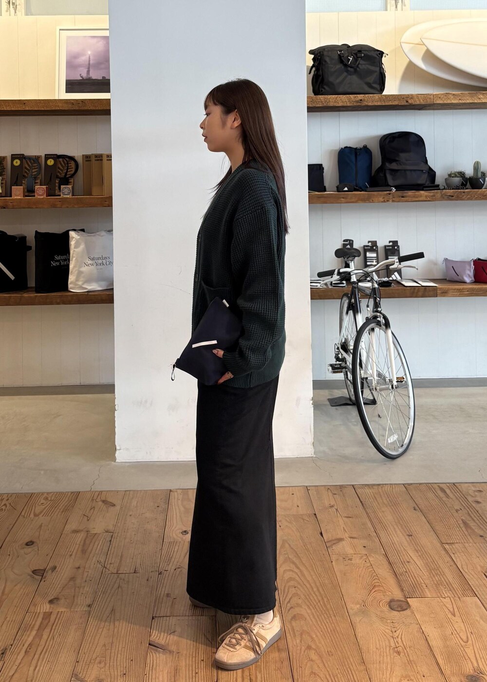 グリーン系のカーディガン/ボレロ、ブラック系のデニムスカートを着用したレディースの秋コーディネートの3枚目の写真