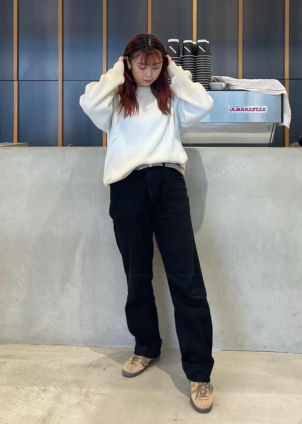 ブラック系のデニムパンツ、ブルー系のニット/セーター、ベージュ系のベルトを着用したレディースの秋コーディネートの3枚目の写真