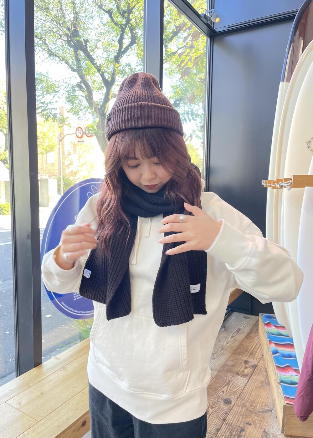 ホワイト系のパーカー、ブラウン系のニットキャップ/ビーニー、ブラック系のマフラーを着用したレディースの冬コーディネートの3枚目の写真