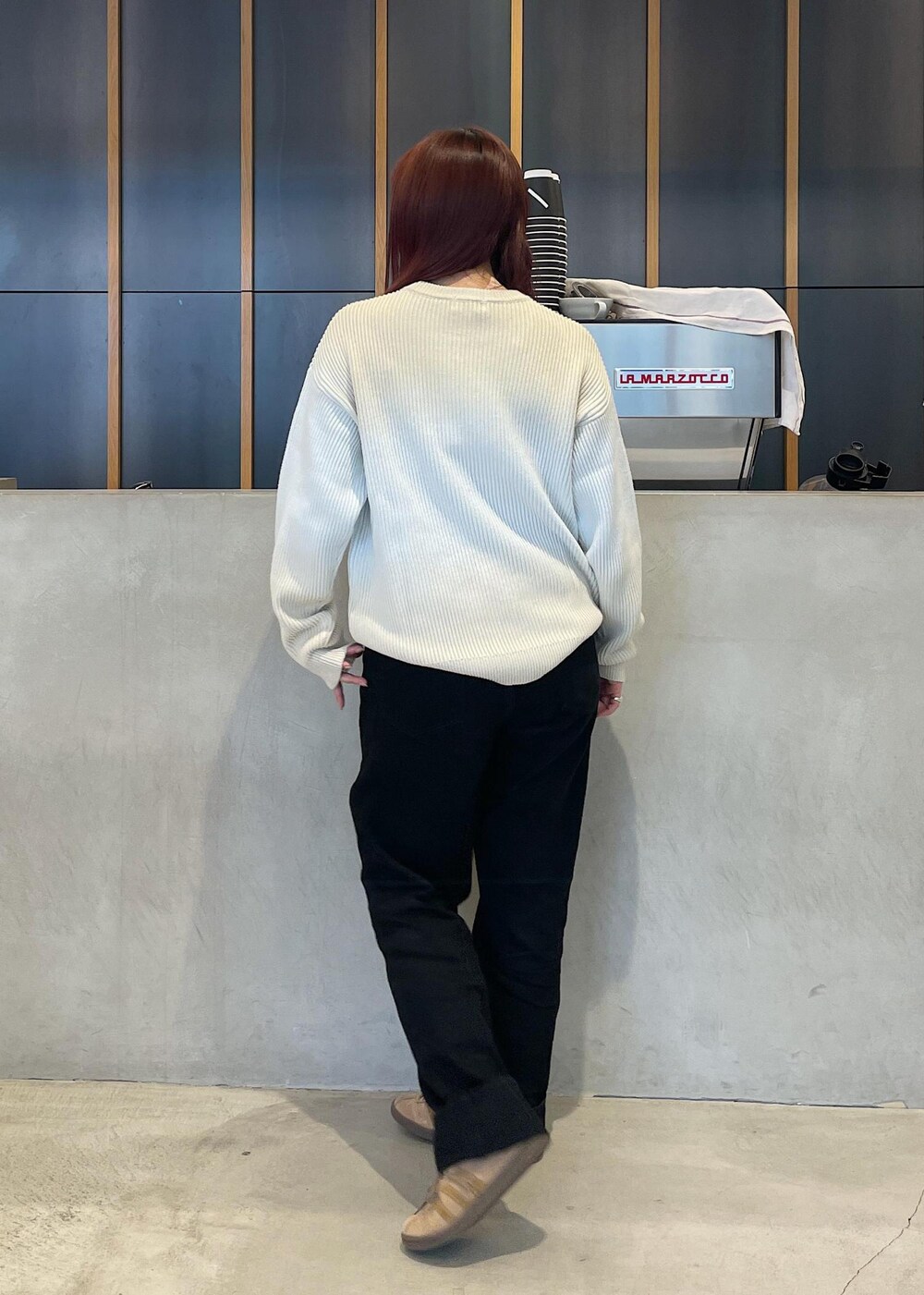 ブラック系のデニムパンツ、ブルー系のニット/セーター、ベージュ系のベルトを着用したレディースの秋コーディネートの4枚目の写真