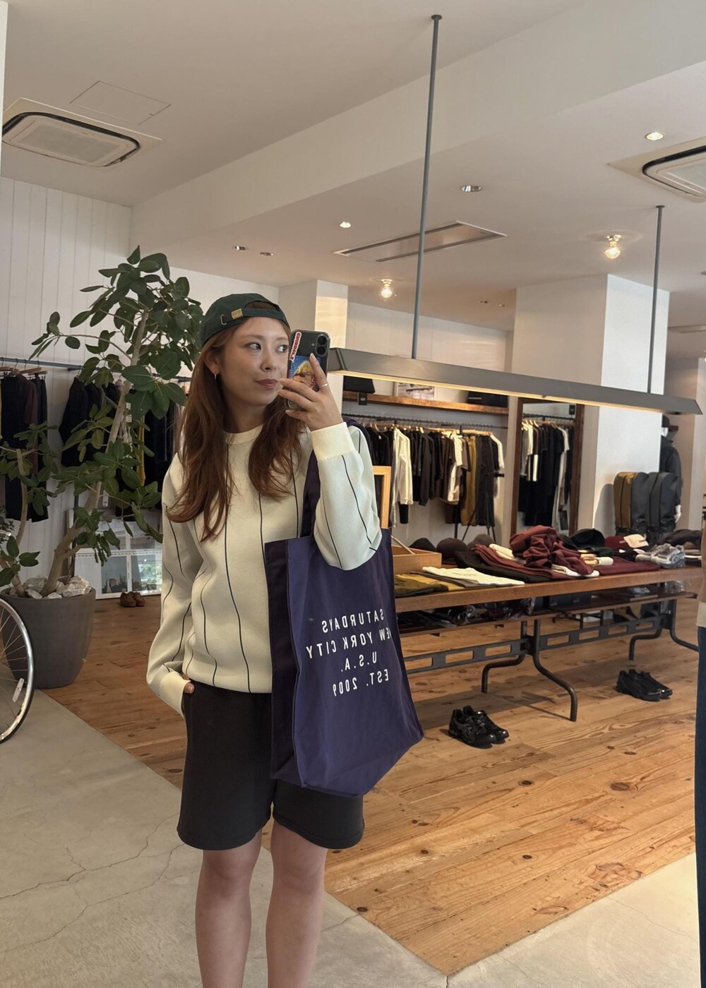 ブラック系のその他パンツ、パープル系のトートバッグ、グリーン系のキャップを着用したレディースの秋コーディネートの5枚目の写真