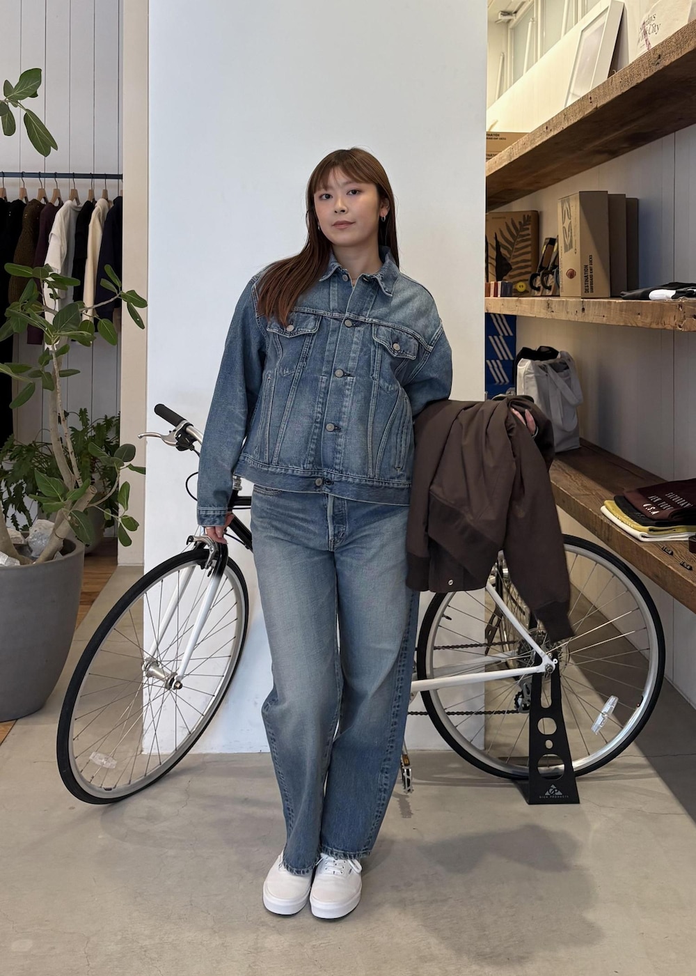 ブルー系のデニムジャケット、ブラウン系のその他アウター、ブルー系のデニムパンツを着用したレディースの冬コーディネートの2枚目の写真