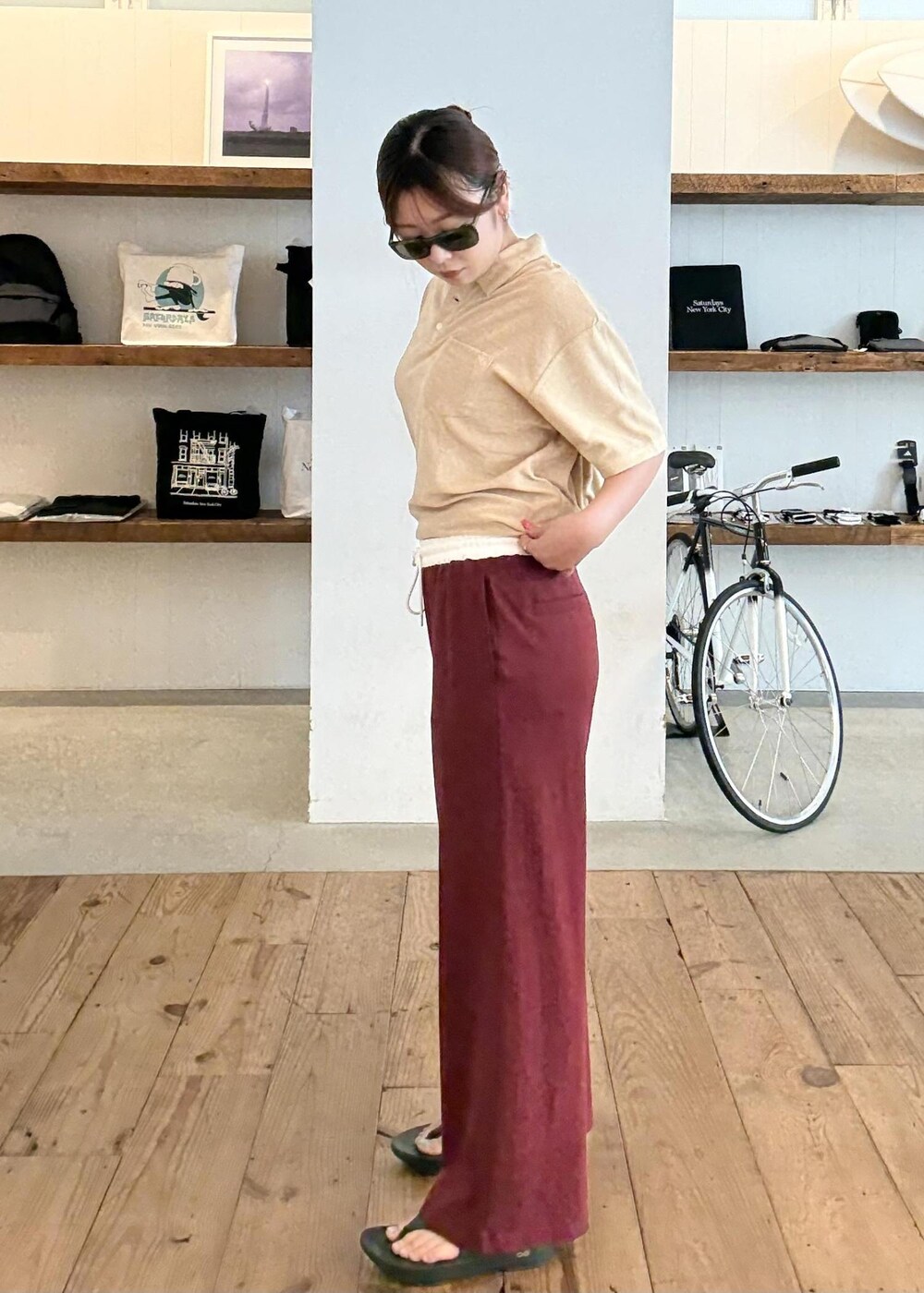 ベージュ系のポロシャツ、ブラック系のサンダル、レッド系のその他パンツを着用したレディースの夏コーディネートの6枚目の写真