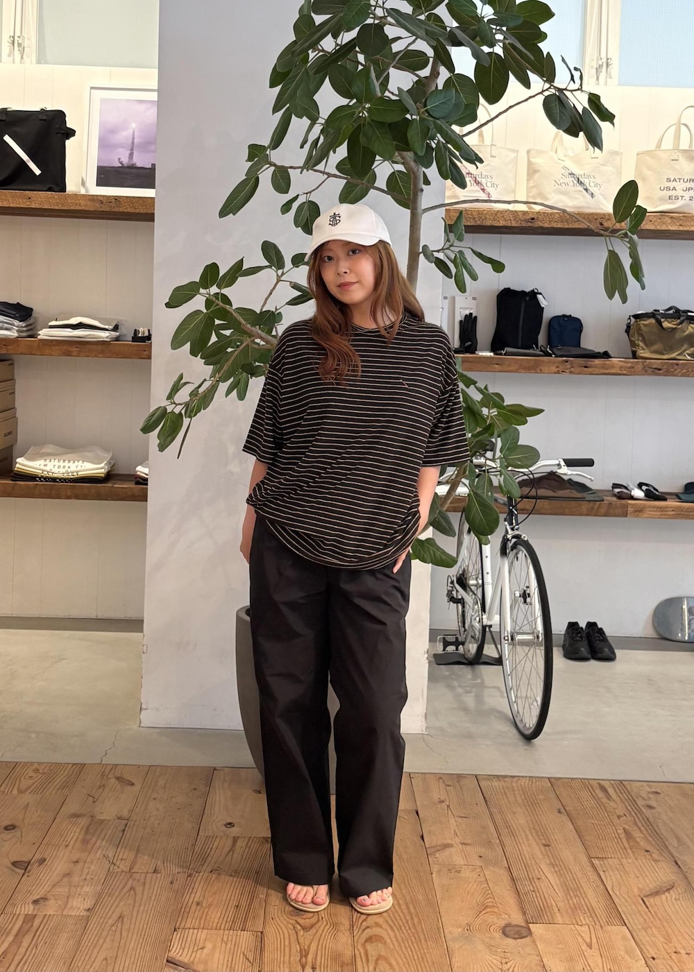 ブラック系のその他パンツ、ブラウン系のTシャツ/カットソー、ホワイト系のキャップを着用したレディースの夏コーディネートの3枚目の写真