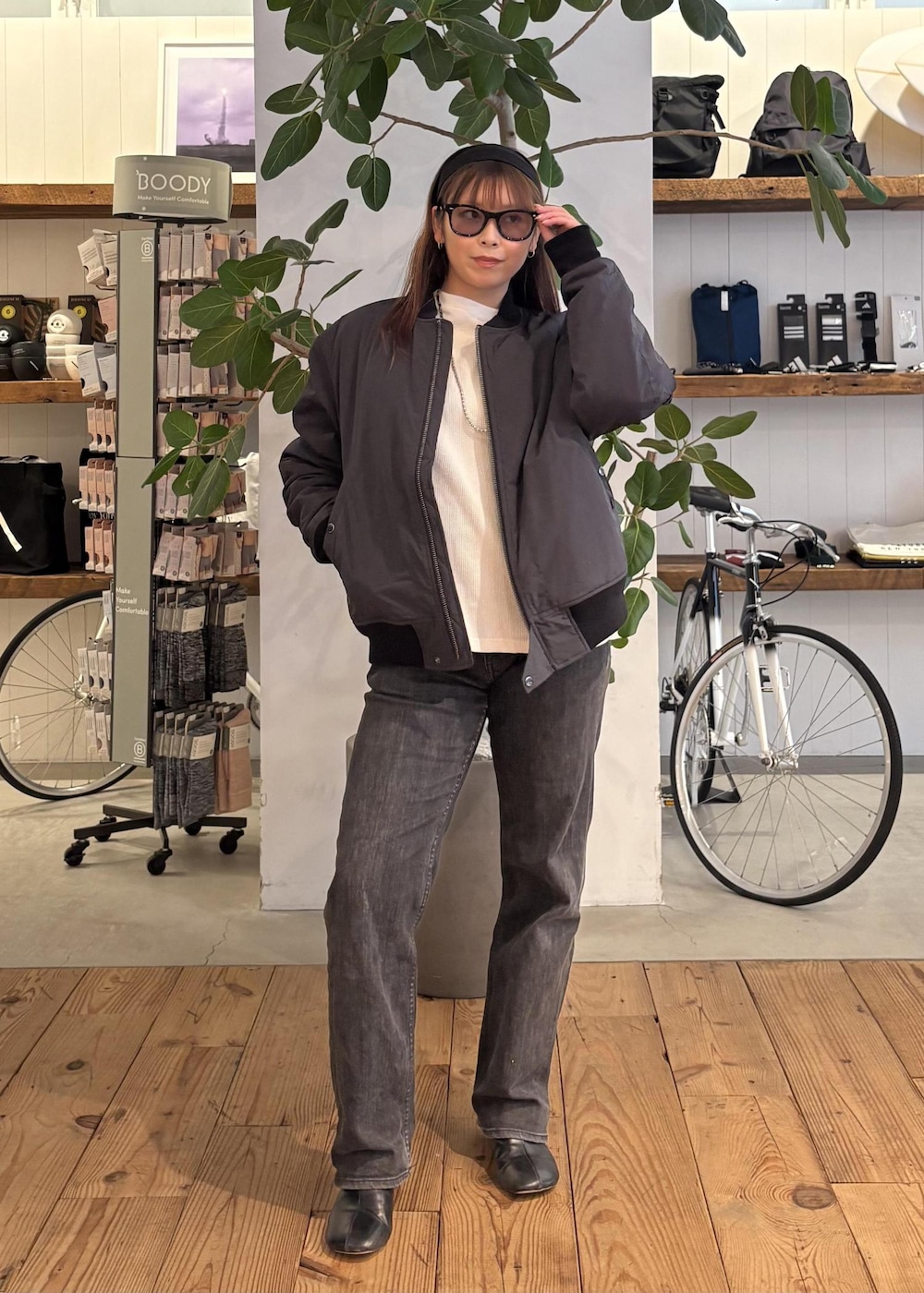 ブラック系のブルゾン、ホワイト系のTシャツ/カットソー、ブラック系のサングラスを着用したレディースの冬コーディネートの2枚目の写真