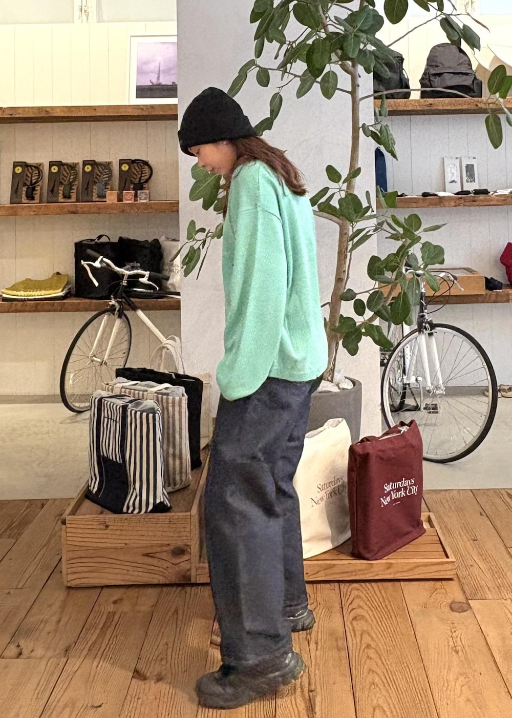 ブルー系のデニムパンツ、ブルー系のニット/セーター、シルバー系のネックレスを着用したレディースの冬コーディネートの2枚目の写真