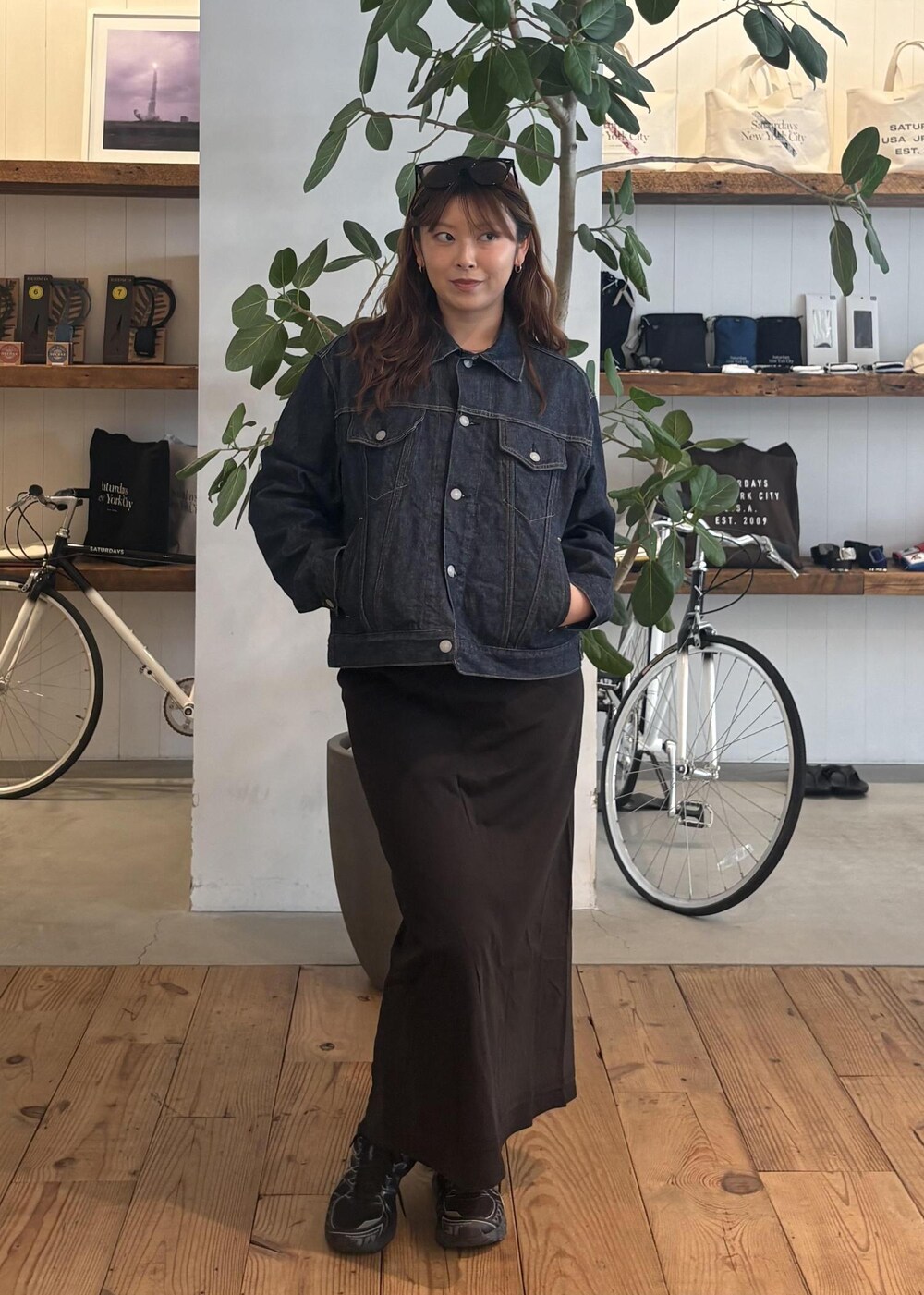 ブルー系のデニムジャケット、ブラック系のスカート、ブラック系のサングラスを着用したレディースの春コーディネートの3枚目の写真