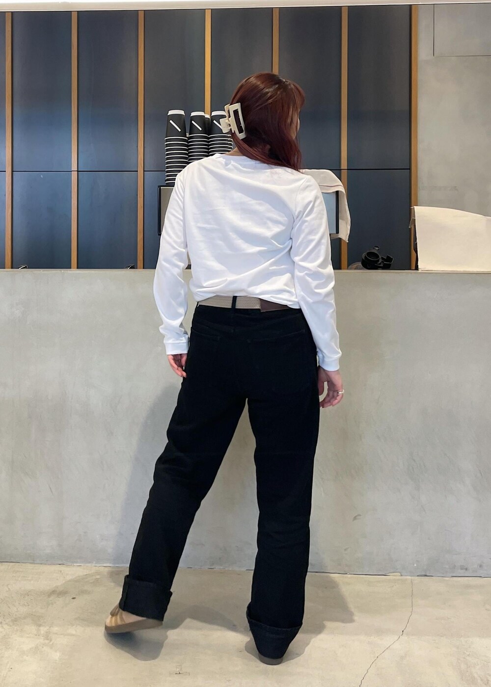 ブラック系のデニムパンツ、ホワイト系のTシャツ/カットソー、ベージュ系のベルトを着用したレディースの秋コーディネートの4枚目の写真