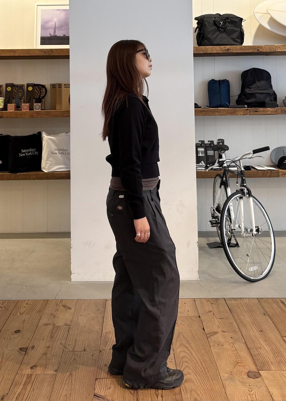 グレー系のスラックス、ブラック系のカーディガン/ボレロ、ブラウン系のサングラスを着用したレディースの秋コーディネートの4枚目の写真