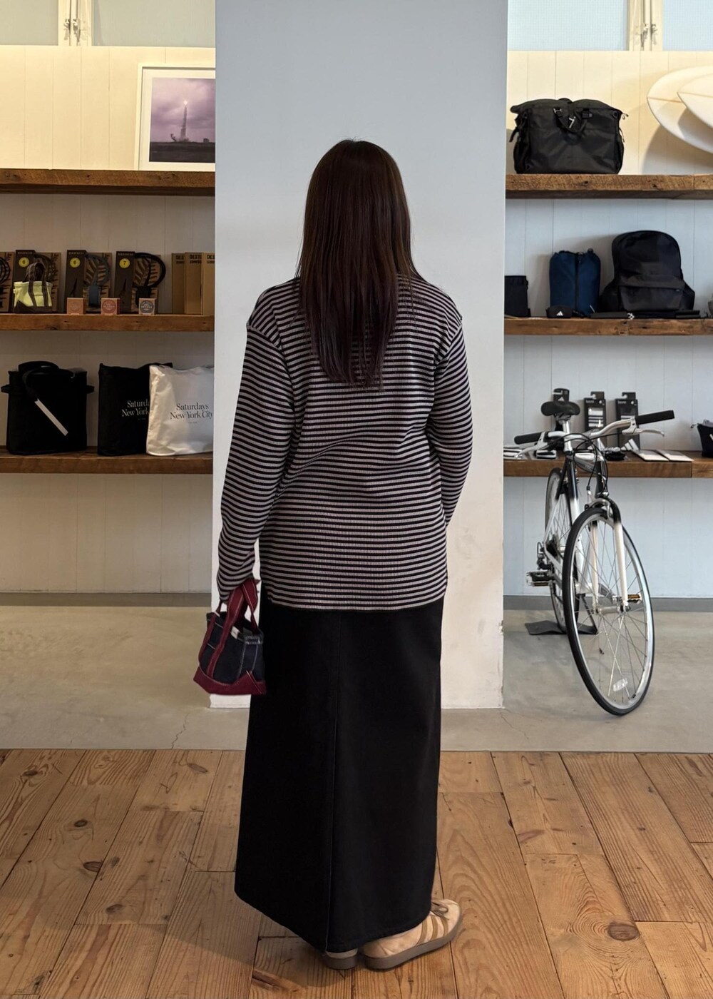 ブルー系のトートバッグ、ブラック系のデニムスカート、グレー系のTシャツ/カットソーを着用したレディースの秋コーディネートの6枚目の写真