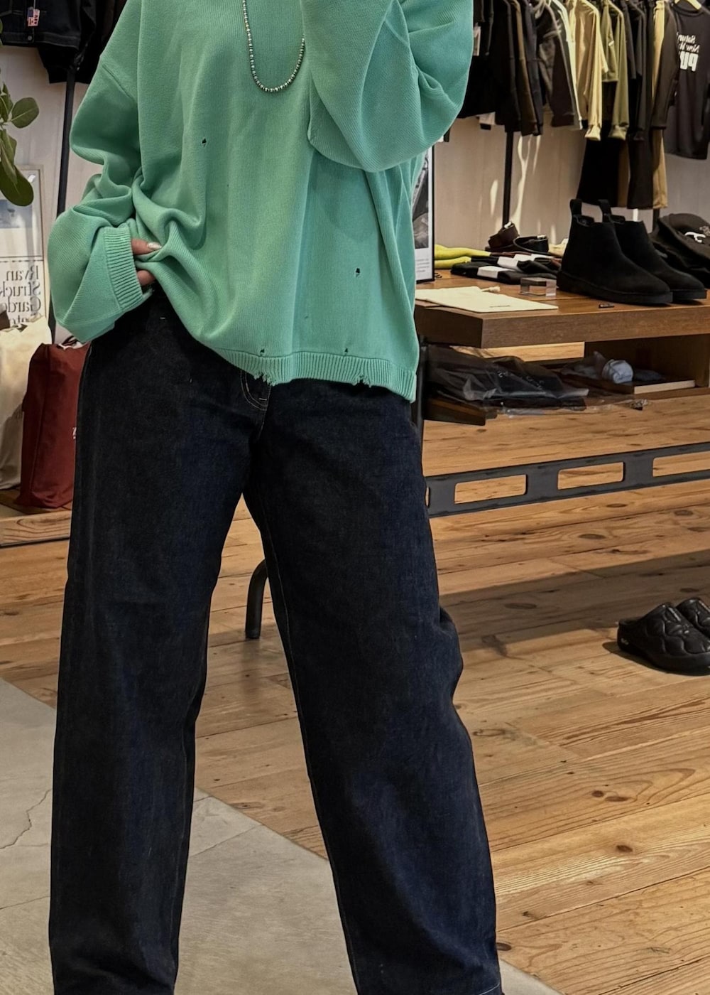 ブルー系のデニムパンツ、ブルー系のニット/セーター、シルバー系のネックレスを着用したレディースの冬コーディネートの6枚目の写真