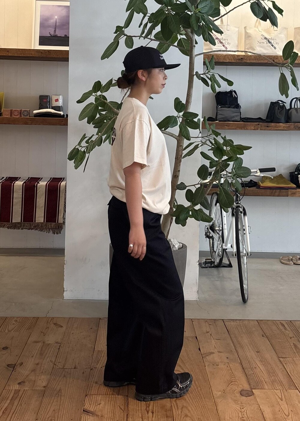 ホワイト系のTシャツ/カットソー、ブルー系のチノパンツ、ブルー系のキャップを着用したレディースの夏コーディネートの4枚目の写真