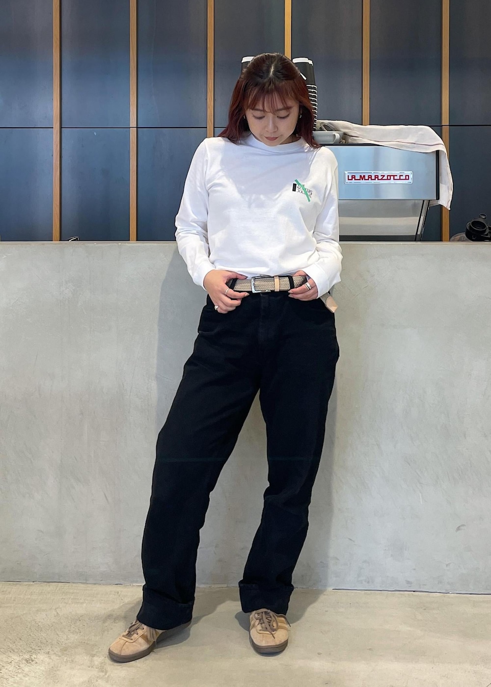 ブラック系のデニムパンツ、ホワイト系のTシャツ/カットソー、ベージュ系のベルトを着用したレディースの秋コーディネートの3枚目の写真