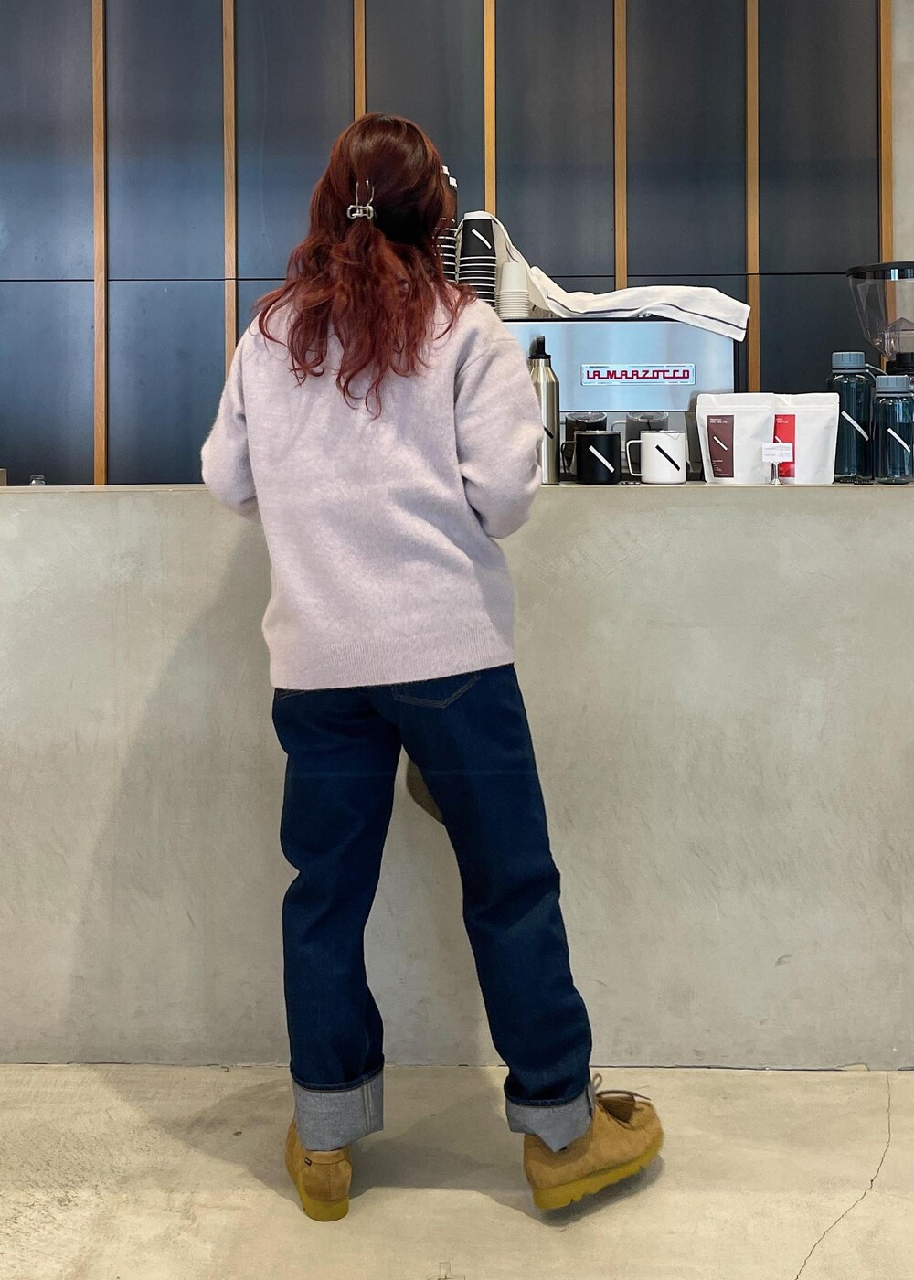ブルー系のデニムパンツ、グリーン系のショルダーバッグを着用したレディースの冬コーディネートの3枚目の写真
