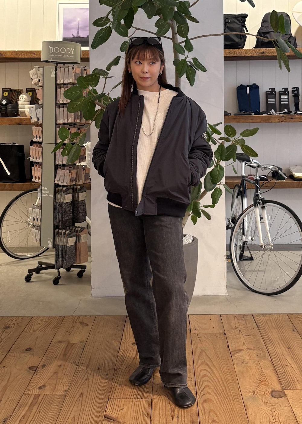 ブラック系のブルゾン、ホワイト系のTシャツ/カットソー、ブラック系のサングラスを着用したレディースの冬コーディネートの4枚目の写真