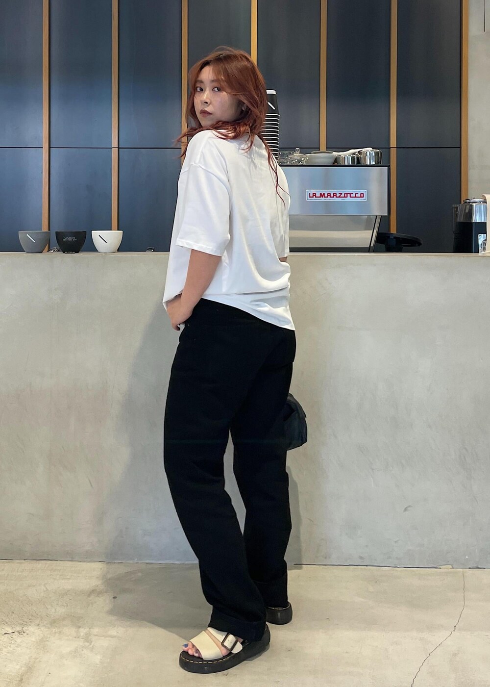 ブラック系のデニムパンツ、ホワイト系のTシャツ/カットソーを着用したレディースの夏コーディネートの2枚目の写真