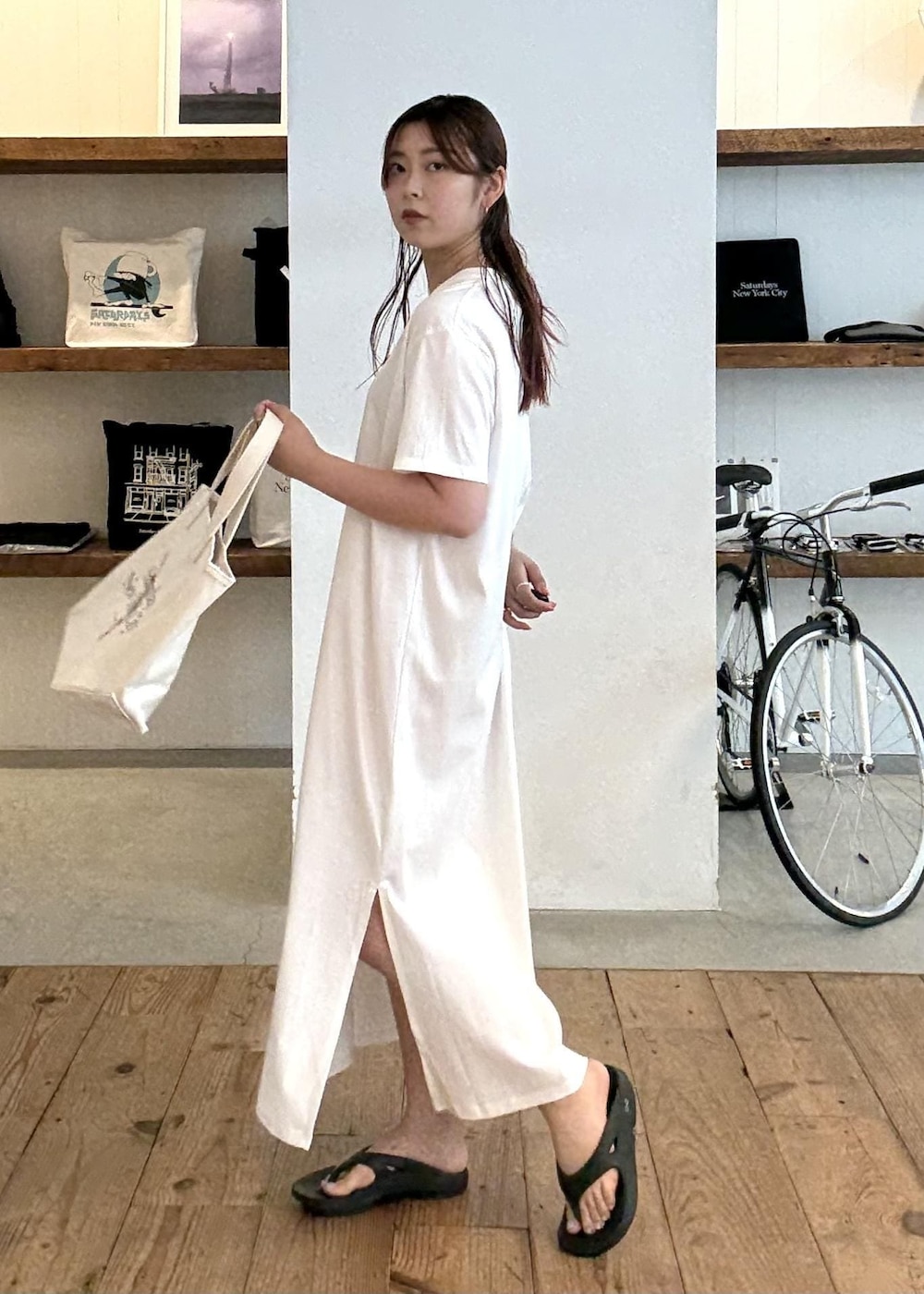 ブラック系のサンダル、ホワイト系のワンピース、レッド系のトートバッグを着用したレディースの夏コーディネートの3枚目の写真