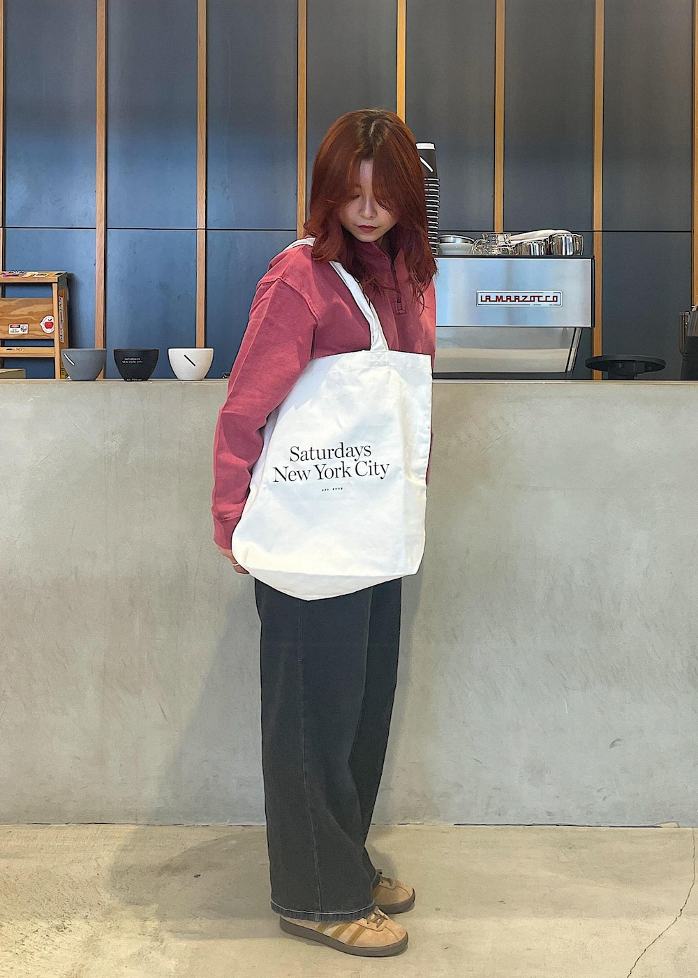 ホワイト系のトートバッグ、レッド系のスウェットを着用したレディースの夏コーディネートの2枚目の写真