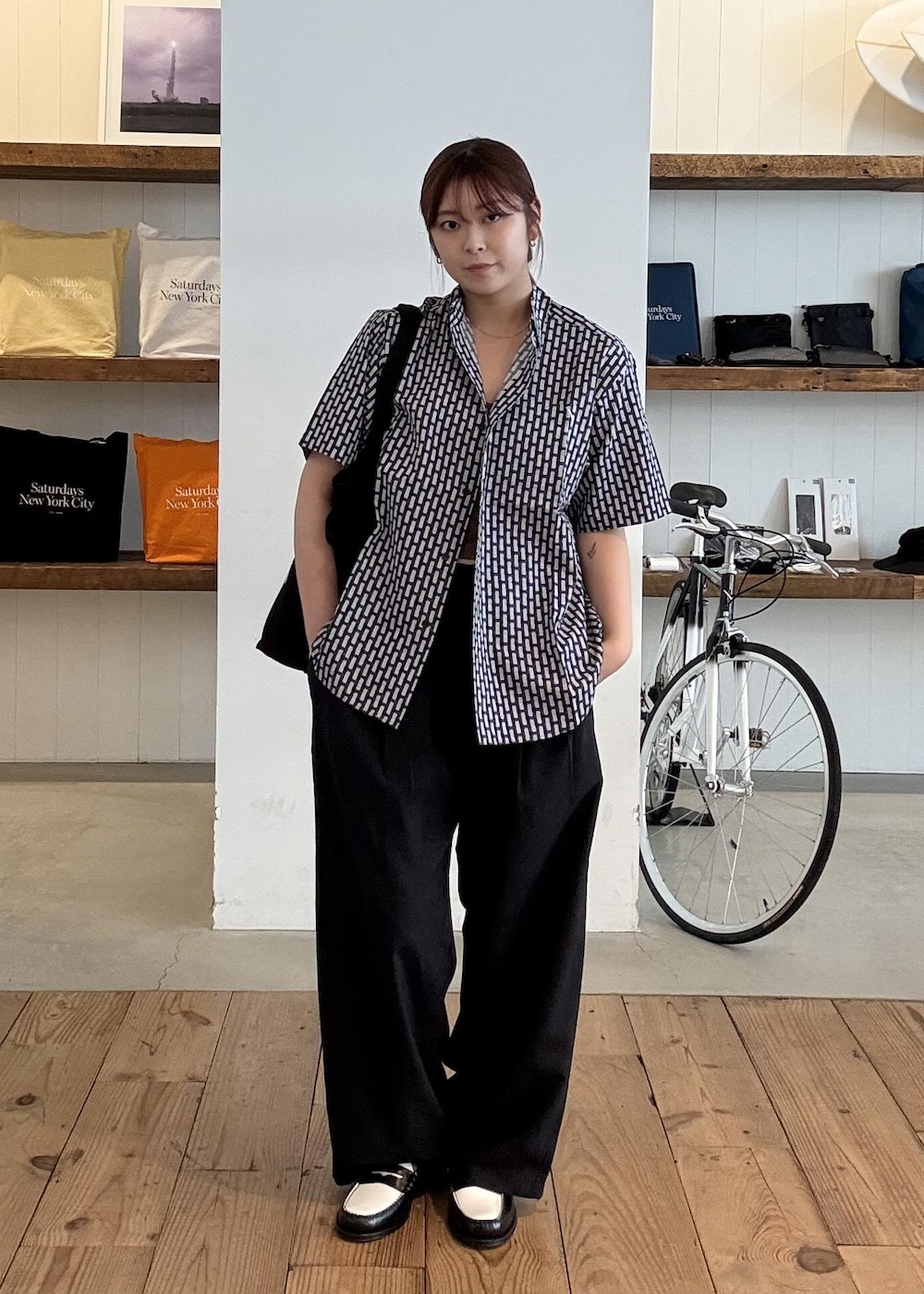 ブラック系のトートバッグを着用したレディースの春コーディネートの2枚目の写真