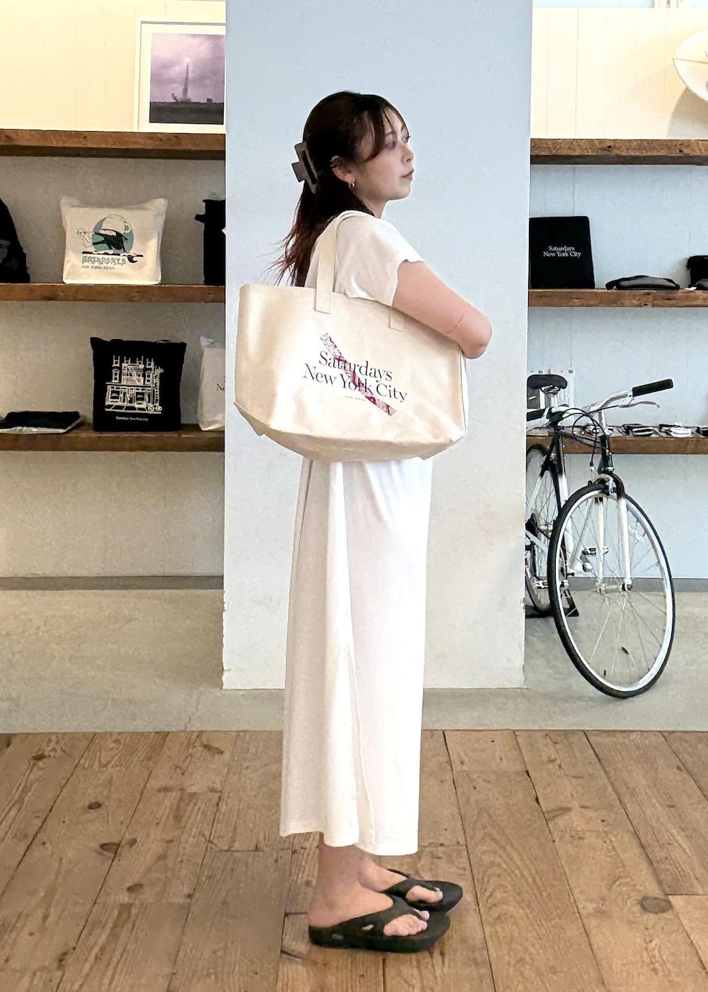 ブラック系のサンダル、ホワイト系のワンピース、レッド系のトートバッグを着用したレディースの夏コーディネートの5枚目の写真