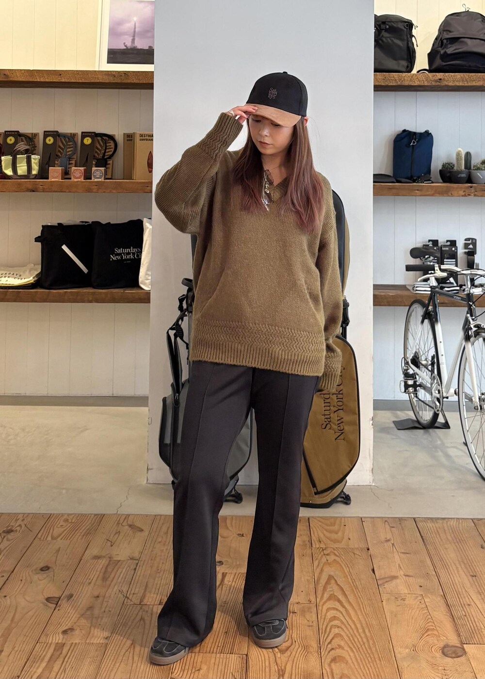 グリーン系のニット/セーター、ブラック系のキャップを着用したレディースの秋コーディネートの3枚目の写真