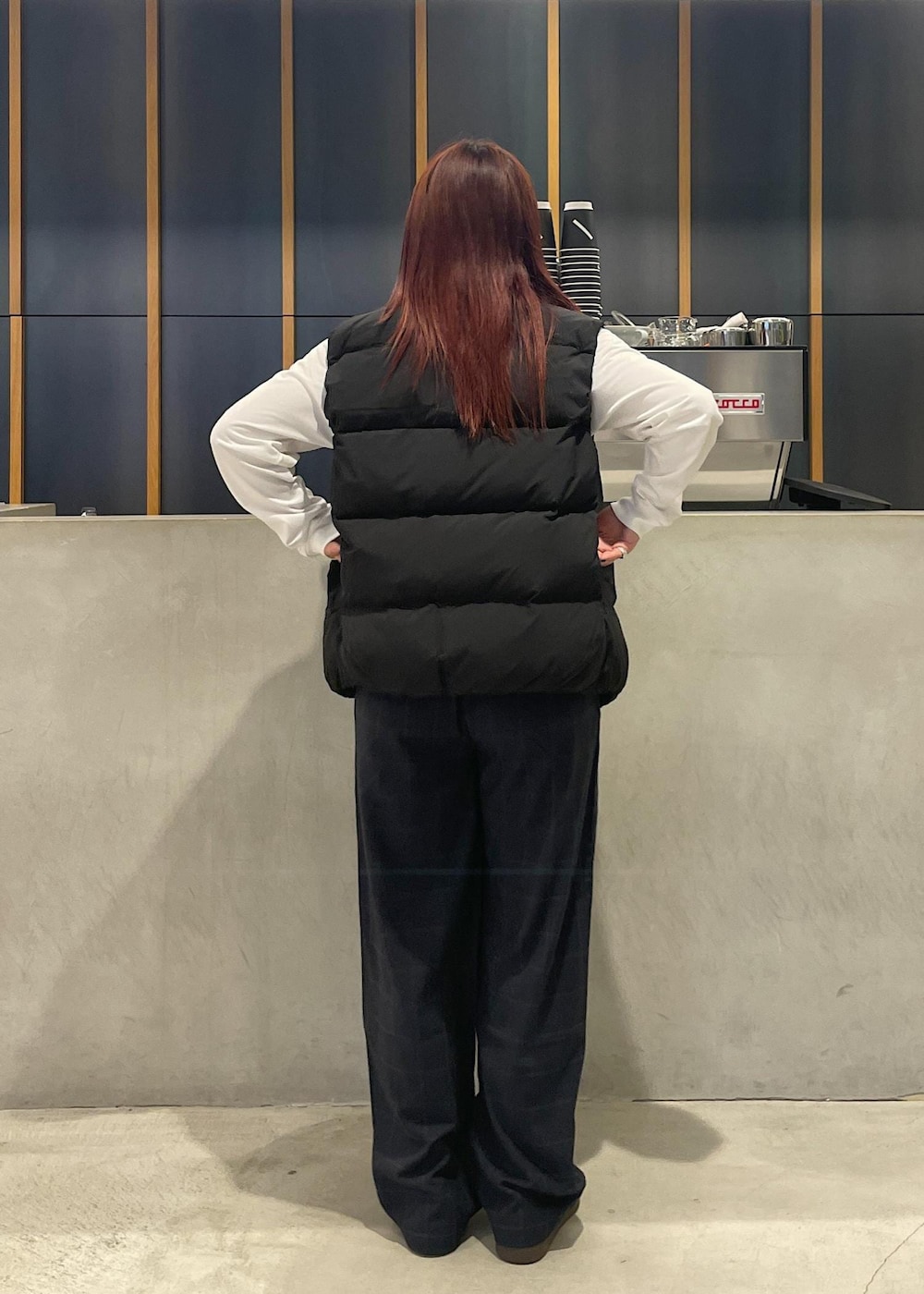 ホワイト系のTシャツ/カットソー、ブラック系のダウンベスト、ブラック系のその他パンツを着用したレディースの秋コーディネートの5枚目の写真