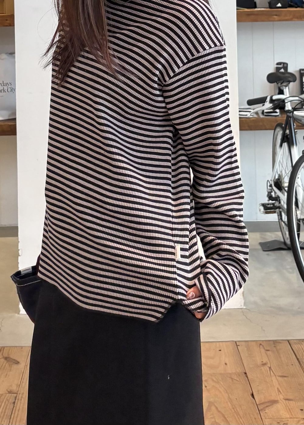 ブルー系のトートバッグ、ブラック系のデニムスカート、グレー系のTシャツ/カットソーを着用したレディースの秋コーディネートの4枚目の写真