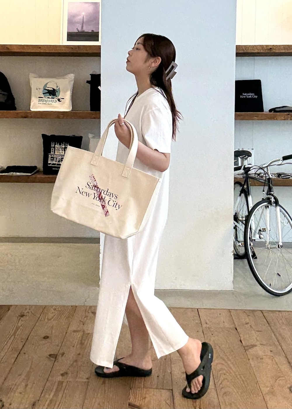 ブラック系のサンダル、ホワイト系のワンピース、レッド系のトートバッグを着用したレディースの夏コーディネートの2枚目の写真