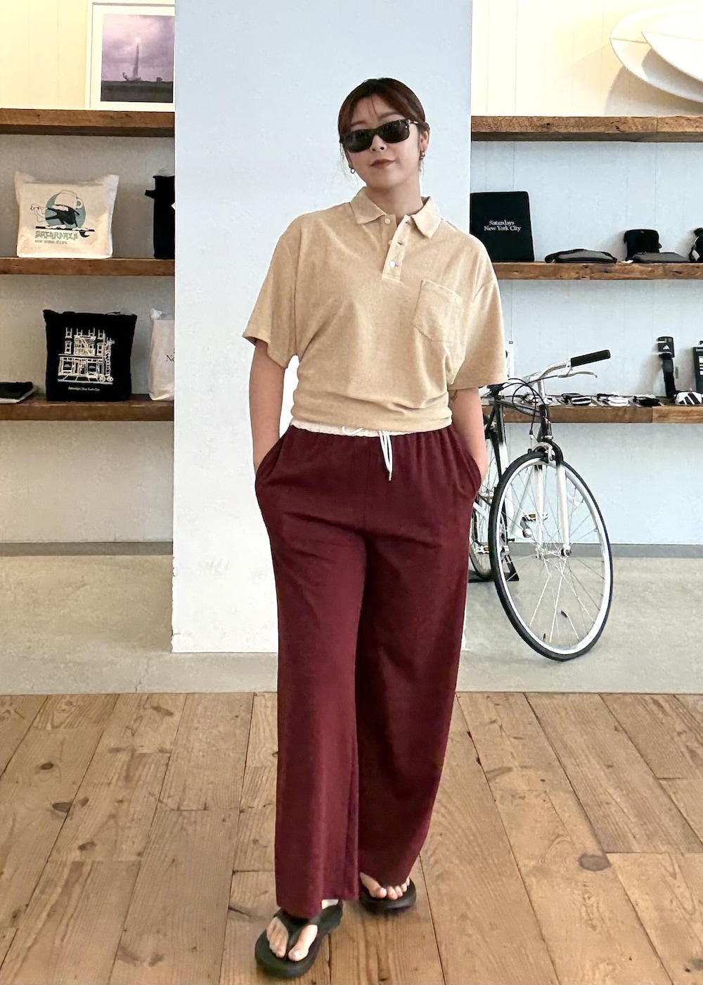 ベージュ系のポロシャツ、ブラック系のサンダル、レッド系のその他パンツを着用したレディースの夏コーディネートの2枚目の写真