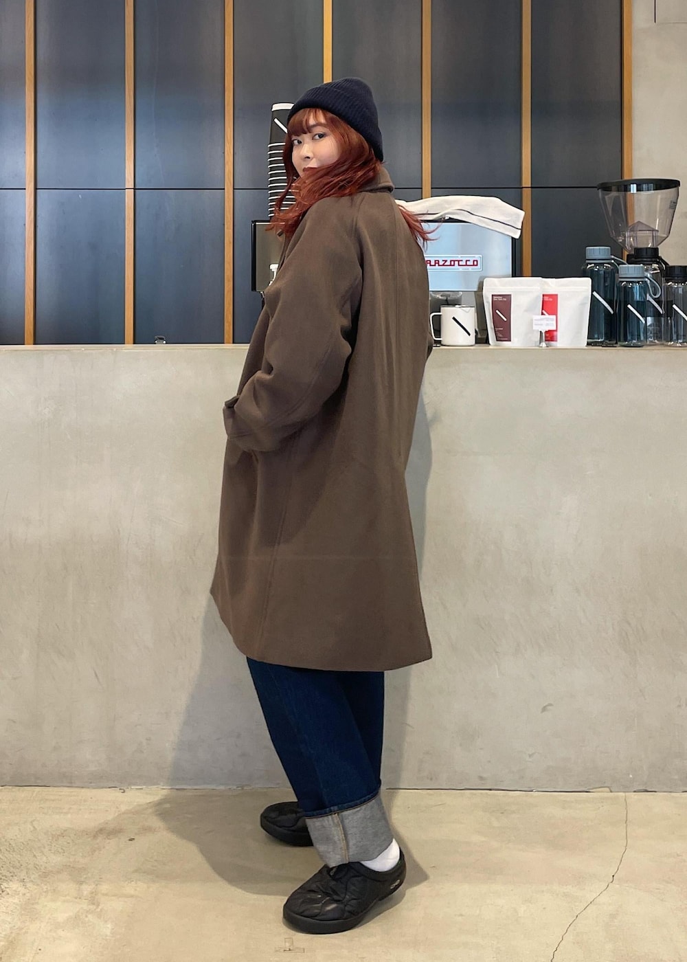 ブルー系のデニムパンツ、ブラック系のサンダル、ブルー系のニットキャップ/ビーニーを着用したレディースの冬コーディネートの2枚目の写真