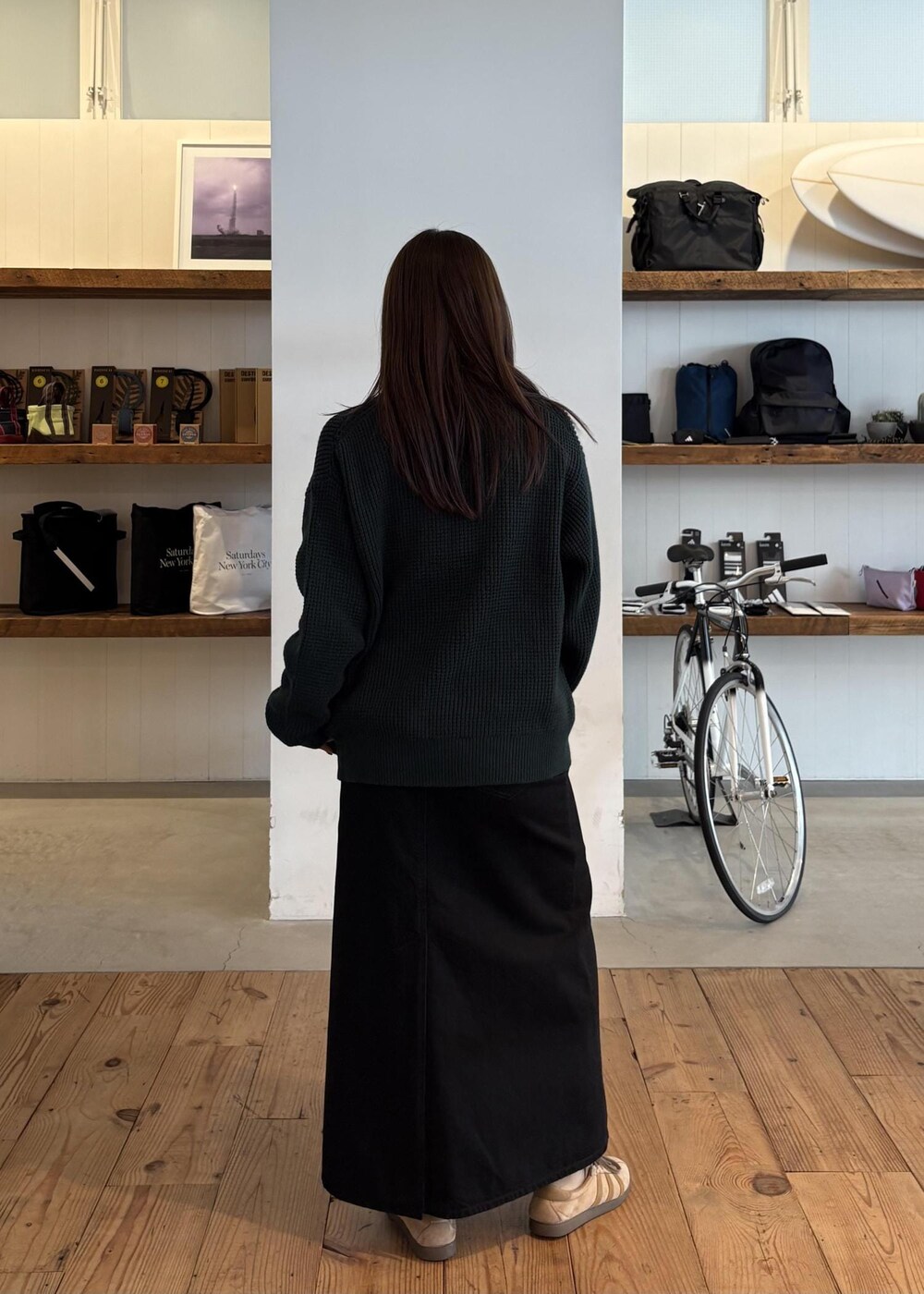 グリーン系のカーディガン/ボレロ、ブラック系のデニムスカートを着用したレディースの秋コーディネートの4枚目の写真