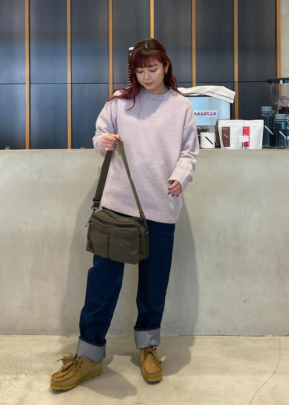 ブルー系のデニムパンツ、グリーン系のショルダーバッグを着用したレディースの冬コーディネートの2枚目の写真