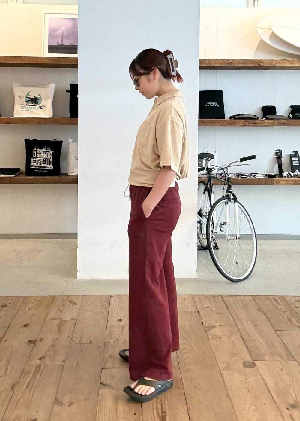 ベージュ系のポロシャツ、ブラック系のサンダル、レッド系のその他パンツを着用したレディースの夏コーディネートの3枚目の写真